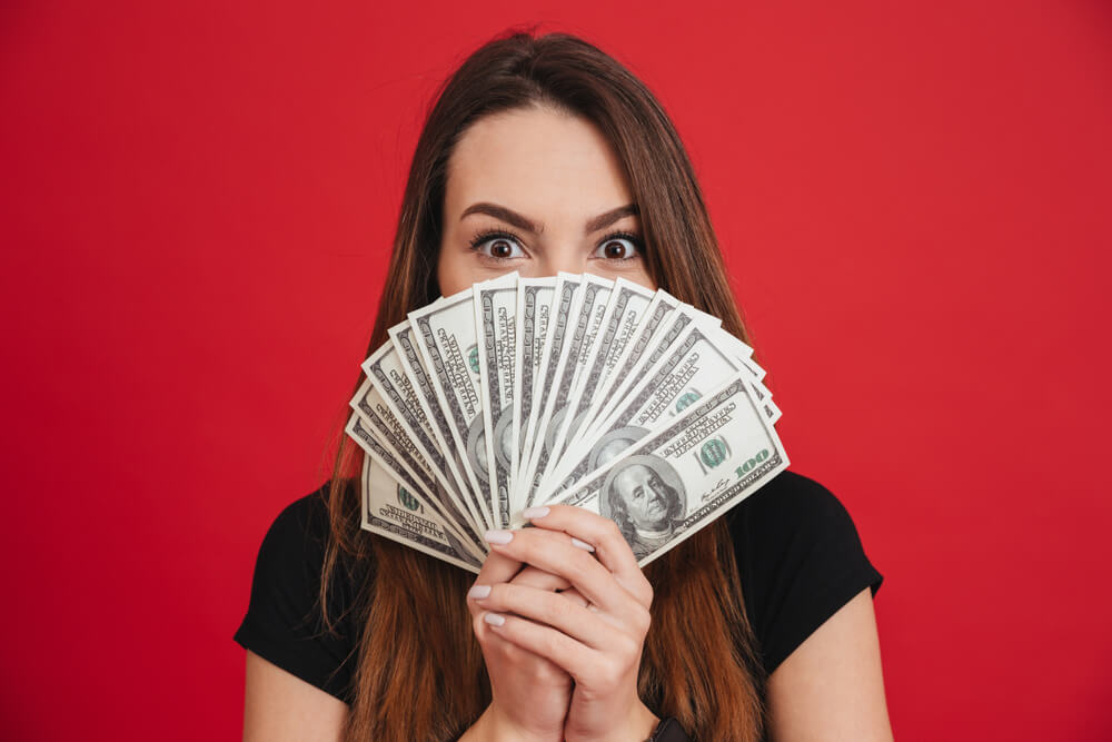 Woman holding cash from small business funding 