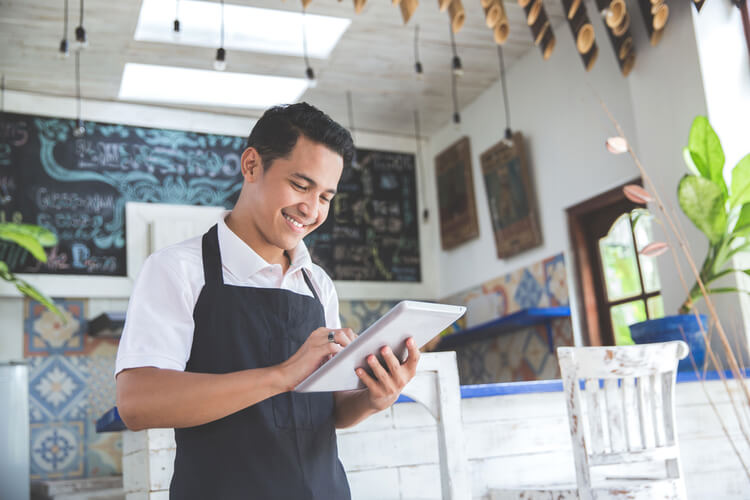 business funding 24 hrs worker in cafe on tablet